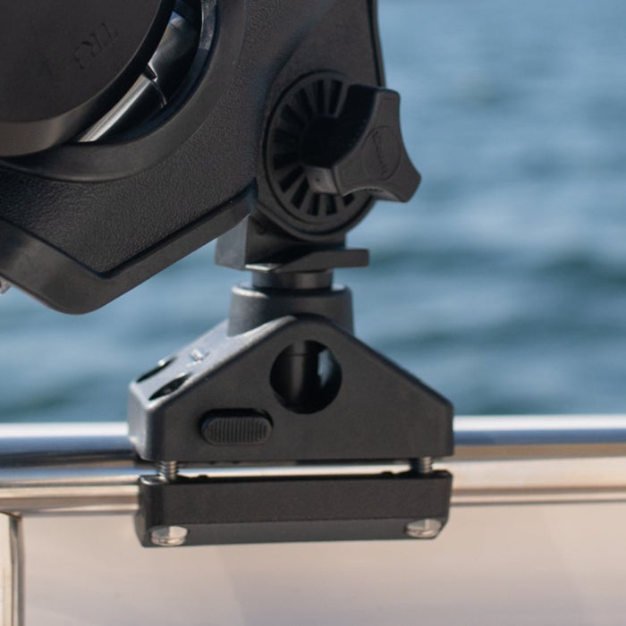 Close-up of a black mounting bracket attached to a metal rail, with a blurred blue water background.