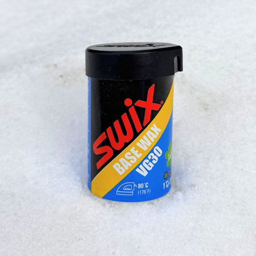 Swix base wax container on a snowy background