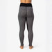 Rear view of a person wearing high-waisted black and white patterned leggings against a plain white studio background.