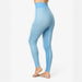 A person wearing high-waisted light blue patterned leggings, shown from the side against a plain white studio background.