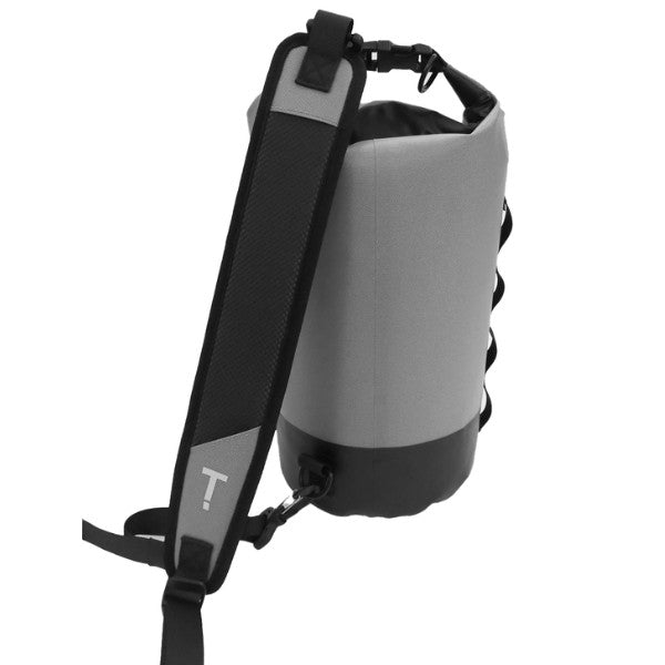 A gray and black dry bag backpack shown from a side angle, featuring a wide black shoulder strap with a gray panel and a white stylized 'T' logo, set against a plain white background.