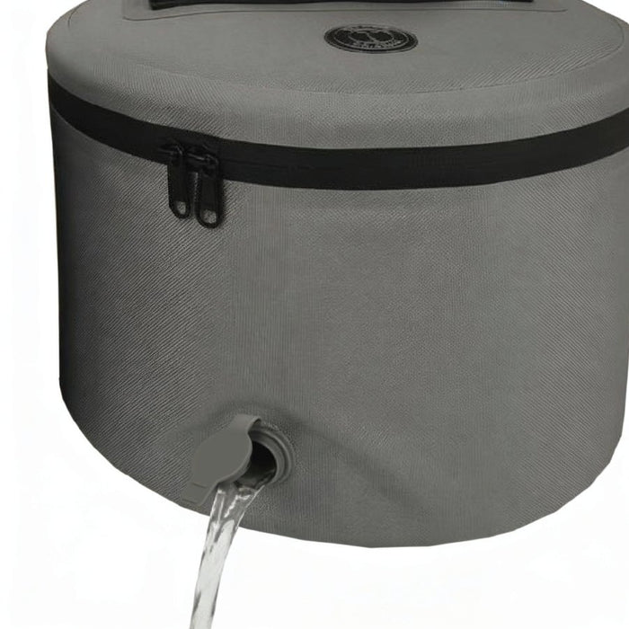 Gray fabric cooler with a black zipper, top handle, and drainage spout with water flowing out, shown on a white background.