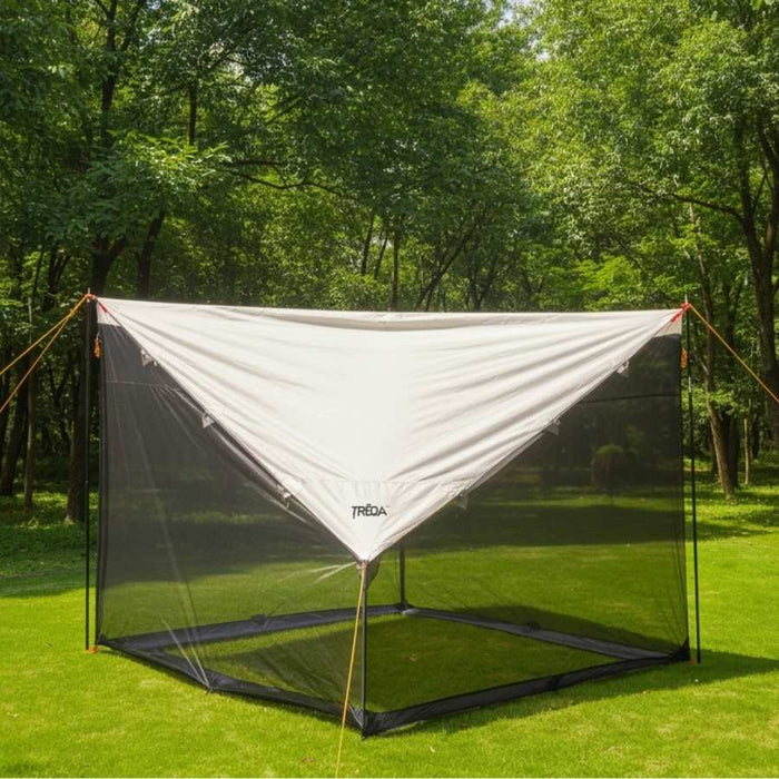 A white and black mesh outdoor canopy tent set up on a green grassy lawn with a backdrop of dense trees. The brand name 'PRAIA' is visible on the front white panel.