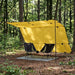 Yellow camping shelter with two chairs in a forest setting