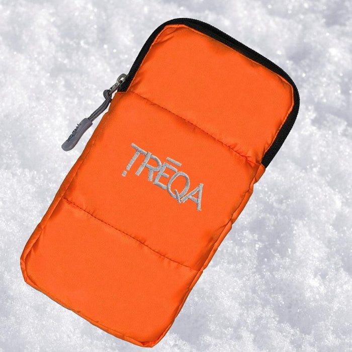 An orange puffer-style zip pouch with black trim and a silver zipper pull, photographed on a snowy white background. The pouch has the word TREQA embroidered in silver on the front.