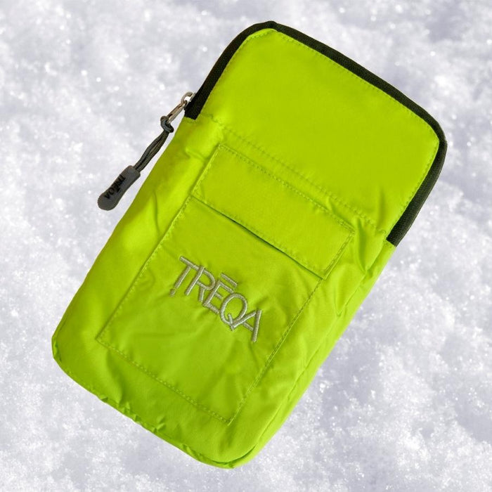 A bright lime green waterproof pouch with black trim and a silver zipper, featuring the embroidered brand name 'TREQA' on the front, shown lying on a bed of white snow.