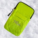 A bright lime green waterproof pouch with black trim and a silver zipper, featuring the embroidered brand name 'TREQA' on the front, shown lying on a bed of white snow.