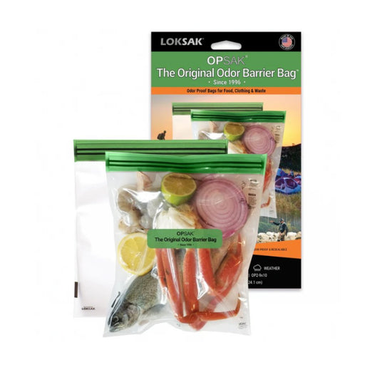 Two clear plastic odor barrier zip bags with green seals in front of their retail packaging. The bags contain food items including a fish, red crab legs, onion, and citrus slices.